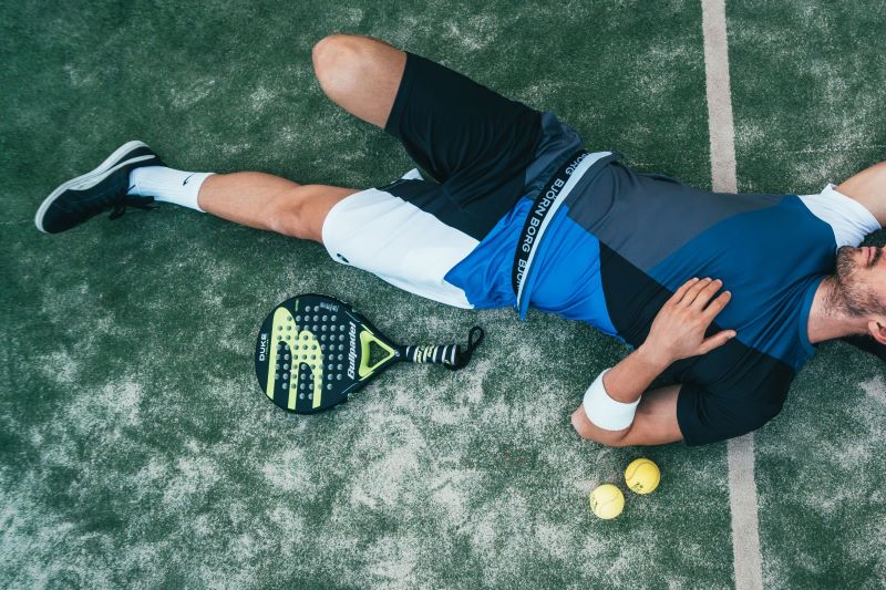 man lying on tennis court