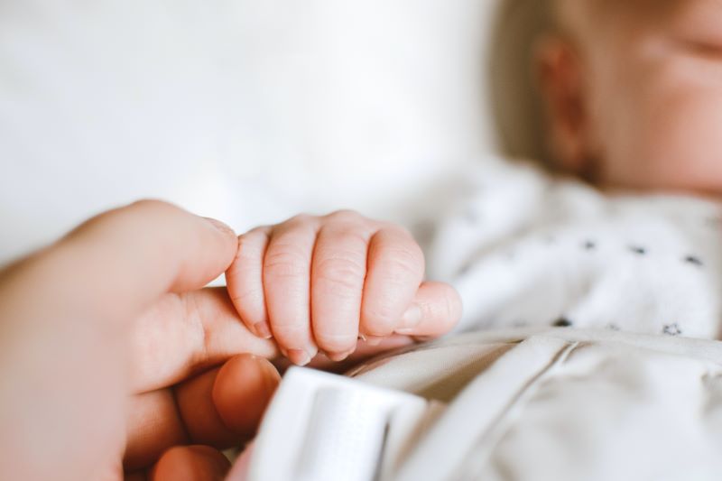 baby holding parent's hand