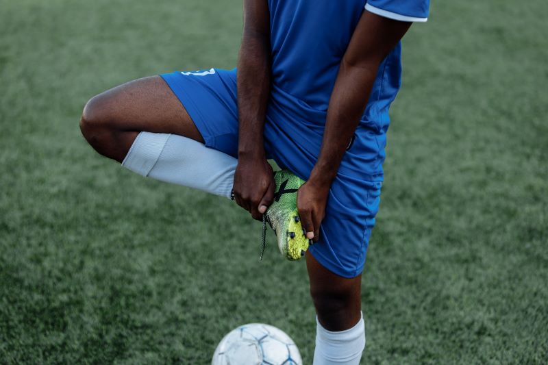 boy in blue soccer jersey stretching
