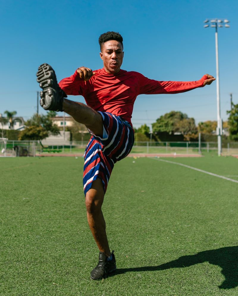man stretching on turf field