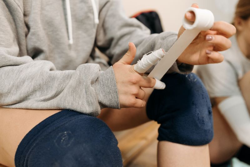 volleyball player wrapping fingers with tape